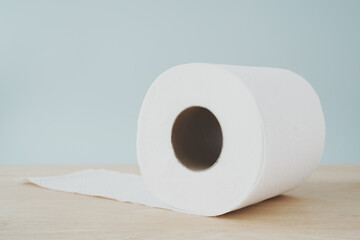 roll of hygiene white tissue paper on wooden desk in soft focus