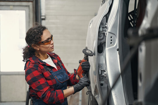 Female auto mechanic repairing car at auto repair shop - Powered by Adobe
