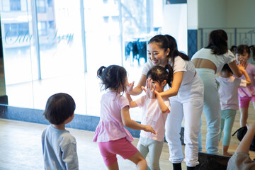 スポーツクラブの先生とハイタッチする幼い少女