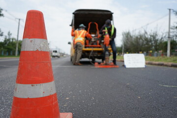 Fototapeta premium Red rubber cone and blurry background image of road maintenance agency work.