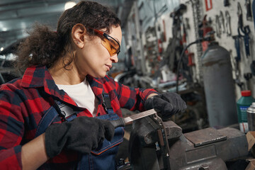 Female auto mechanic working in car repair garage