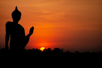 Fototapeta na wymiar Silhouette with black buddha on sunset background.
