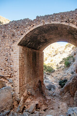 Ancient ruined stone arch in the mountains, Crete island, Greece.