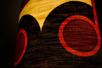  A 60s modern red bedside lamp shade base and fabric illuminated vintage midcentury design front side view isolated detail macro closeup with warm orange light studio living room 60s furniture 
