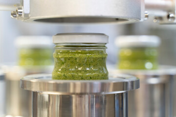 close up on Pesto sauce Industrial process. vacuum sealing machine for canned food. production of...