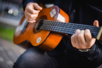 Street musician. A man plays the guitar on a city street.