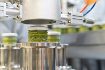 close up on Pesto sauce Industrial process. vacuum sealing machine for canned food. production of...