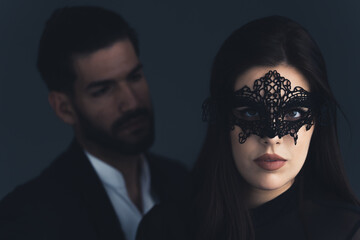 beautiful Latin woman with theatrical mask and handsome Latin American man over black background....