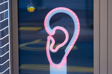 Illuminated ear with red LEDs at shopping window at City of Jona on a sunny spring day. Photo taken April 28th, 2022, Rapperswil-Jona, Switzerland.