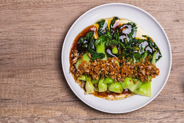 Baby Bok choy or chinese cabbage in oyster sauce with and fried garlic. - obrazy, fototapety, plakaty