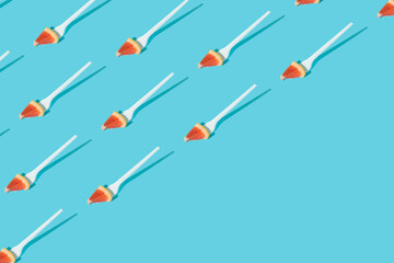 Pattern made of grapefruit sliced with fork on sunny blue background. Creative heathy snack, food, fruit or vegetarian concept. Pop art. Summer background.