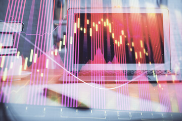 Obraz premium Forex market graph hologram and personal computer on background. Multi exposure. Concept of investment.