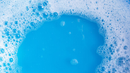 Detergent foam bubble on blue background. - obrazy, fototapety, plakaty