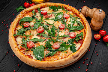 Tasty hot italian pizza on black wooden table.