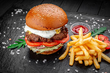 An american burger with fried potatoes