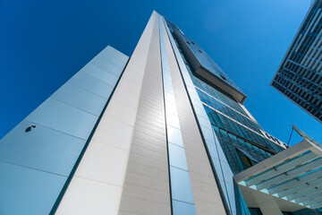 Modern glass buildings in the city on a sunny clear day with a blue sky, photo from bottom to top