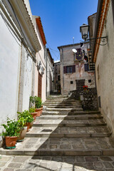 Fototapeta na wymiar A narrow street between the old houses of Marsicovetere, a village in the mountains of Basilicata, Italy.