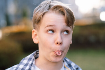 Naughty teenager makes faces at the camera, shows his tongue and indulges