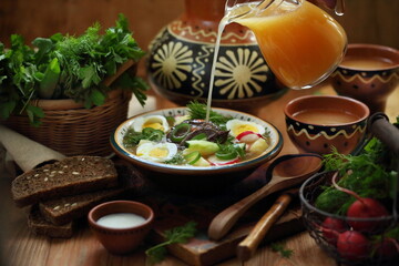 Okroshka on homemade kvass with beef on a wooden table