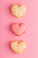 Naklejka na ściany i meble Heart shaped Sweet macarons on pink background.