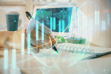Fototapeta na wymiar Financial forex graph drawn over hands taking notes background. Concept of research. Multi exposure