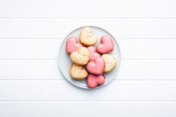 Heart shaped Sweet macarons on plate on white table.