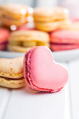 Heart shaped Sweet macarons on white table.