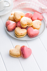 Heart shaped Sweet macarons on white table.