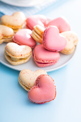 Fototapeta na wymiar Heart shaped Sweet macarons on blue table.