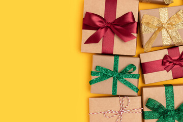 Wrapped gifts with ribbons on a yellow background. Boxing day concept with place for text.