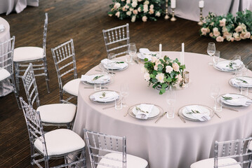 Wedding outdoor table serving. Wedding luxury decor. Wedding presidium for the newlyweds. Beautiful decor with pastel roses, candles and greenery.