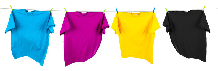 Colorful CMYK colored t-shirts on clothes line isolated white background. Cyan magenta yellow key...