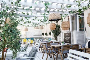 Fototapeta na wymiar Summer terrace in a cafe, white wooden furniture.