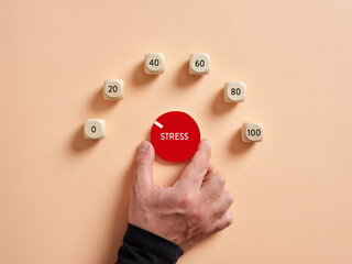 Hand turning stress level meter indicating low level of stress. Reducing or removing stress