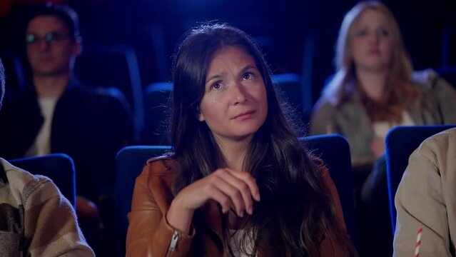 Crying in a movie theater - girl watches an emotional drama movie - people photography in a cinema