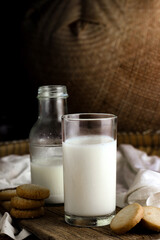 glass of milk and cookies with wooden background