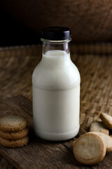 glass of milk and cookies with wooden background