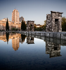 panoramic of the Debod temple reflected in a pond of water with blue sky in the background the...