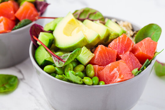 Hawaiian Poke - Brown Rice, Salmon, Edamame, Cucumber And Avocado In Gray Bowl, Marble Background. Fish Fresh Salad For A Healthy Diet.