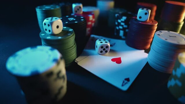 Casino chips with dice and playing cards on a dark table. Concept of gambling or poker and entertainment. Close up macro shoot. Online casino betting
