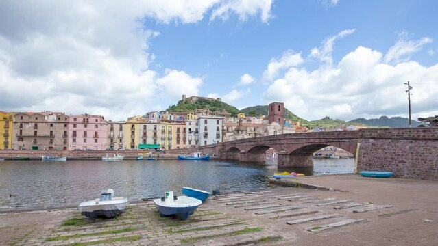 Timelapse of charming village and boats near Temo river and Roman bridge, Malaspina Castle in background, Bosa, Italy