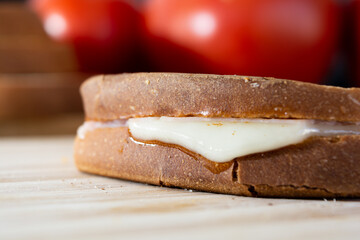 close up on hot cheese sandwich made of cheese and ham on wooden surface