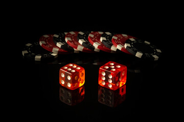 Dice and chips obtained from winnings while playing Craps. The idea of the game on a black...