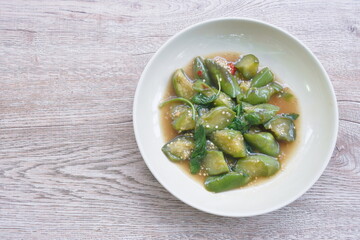 stir fried slice long green eggplant with chili and basil leaf on plate