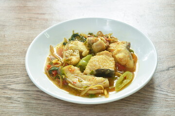 spicy fried Asian redtail catfish with herb and chili on plate