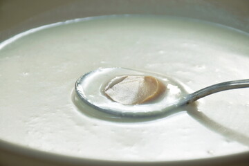 creamy soup topping slice champignon mushrooms scooping by spoon on plate