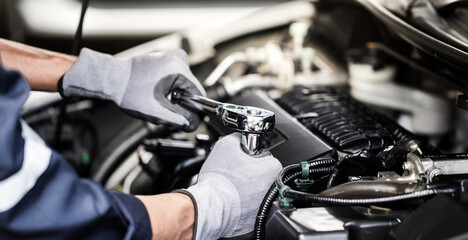 Professional mechanic working on the engine of the car in the garage. Car repair service.