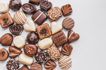 Assortment of dark, white and milk chocolate isolated on white background. Truffle, candy with decoration design. Various candy fillings. View from above