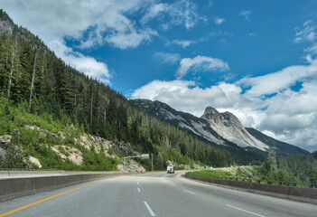 Naklejka premium Slow curve on the Coquihalla highway with massive rocky mountain view