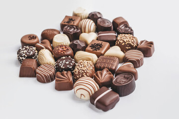 Assortment of dark, white and milk chocolate on white background